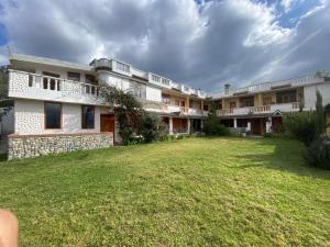 a large building with a yard in front of it at Hostal Curiñan in Otavalo