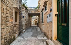 an alley in an old town with a green door at Three-Bedroom Apartment In Povlja in Povlja +18 photos