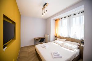a bedroom with a bed with white sheets and a tv at Show MI Rooms Milano - Rho Fiera & San Siro - Free Parking in Milan
