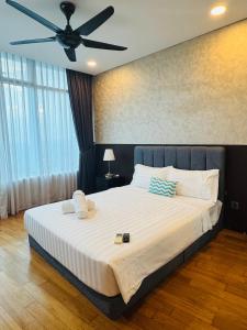 a bedroom with a large bed with a ceiling fan at Vortex suites klcc by paradise in Kualalampur city in Kuala Lumpur