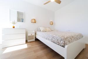 a white bedroom with a bed and a dresser at Guanabara Sunset in Puerto Rico de Gran Canaria +15 photos