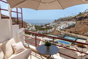 a balcony with a table and a view of a city at Guanabara Sunset in Puerto Rico de Gran Canaria