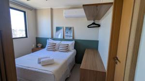 a small bedroom with a bed and a table at Studio Aconchegante 200m praia Pajuçara e P Verde in Maceió +90 photos