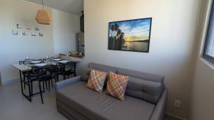 a living room with a couch and a dining table at Studio Aconchegante 200m praia Pajuçara e P Verde in Maceió