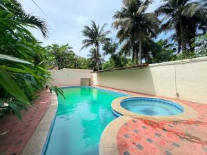 ein Swimmingpool vor einem Haus mit Palmen in der Unterkunft Hawa residency in Chennai