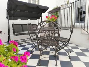 a table and chair on a porch with flowers at LianHome b&b "Terrazzino" in Lucera