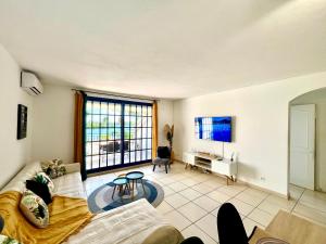 a living room with a couch and a table at Blue Marine Apartment in Baie Nettle