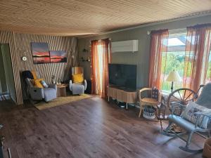 a living room with chairs and a flat screen tv at Perfect Holiday home Senja in Senja