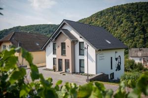 una casa con una montagna sullo sfondo di Genießen- Entspannen- Wohlfühlen-Komfortable Ferienwohnungen - Weingut Erich Serwazi a Mesenich