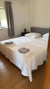 a bedroom with a white bed with towels on it at Apartments Branimir in Murter