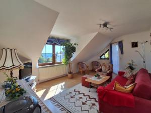 a living room with a red couch and a table at Ferienwohnung Fichtelwald in Fichtelberg