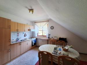 a kitchen with a table and a sink and a window at Ferienwohnung Fichtelwald in Fichtelberg