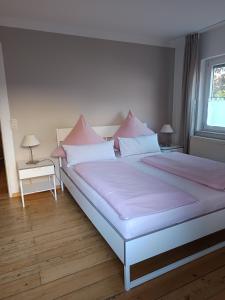 a bedroom with a large bed with pink pillows at Haus Toni in Bad Füssing