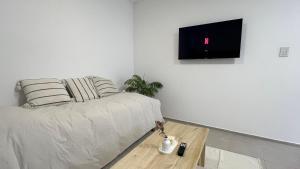 a living room with a couch and a tv on a wall at Temporario Sur, hasta 4 personas con 3 camas, General Roca in General Roca