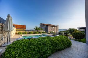 a house with a swimming pool and an umbrella at Apartments Villa Residenca in Novi Vinodolski