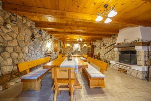 a dining room with a table and benches and a stone wall at Apartments Villa Residenca in Novi Vinodolski