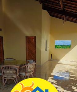 a dining room with a table and chairs and a painting at ChacaraSophya in Aquiraz