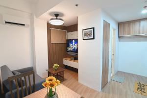 Baksanにある1 Cozy Bedroom Condo Unit-Apple One Banawa Cebuのテーブルとテレビのあるリビングルーム