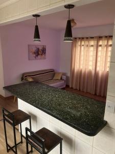 a kitchen with a green counter top and a living room at Panamá 90 - 22 in Poços de Caldas