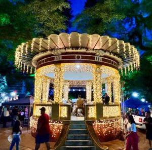 a gazebo with christmas lights and people walking around it at Panamá 90 - 22 in Poços de Caldas +56 photos
