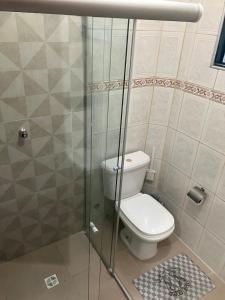 a bathroom with a toilet and a glass shower at Panamá 90 - 22 in Poços de Caldas