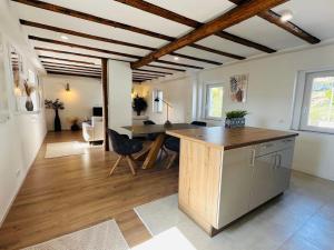 a kitchen and living room with a wooden ceiling at Sehr gut ausgestattetes Einfamilienhaus in Hochspeyer