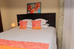 a bedroom with a bed with orange and white pillows at Royal Homes in Nairobi