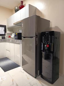 un grand réfrigérateur dans une cuisine avec sa porte ouverte dans l'établissement ZMZ Silang Transient House near Tagaytay, à Silang