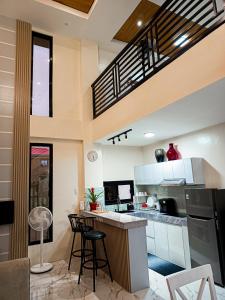 une cuisine avec un comptoir et des tabourets dans une pièce dans l'établissement ZMZ Silang Transient House near Tagaytay, à Silang