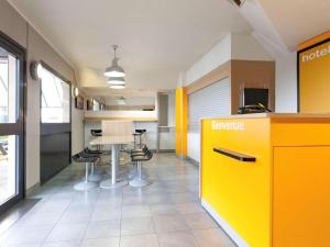 an office with a yellow counter and a table and chairs at Unisotel Colmar Parc Des Exposition EX F1 in Colmar