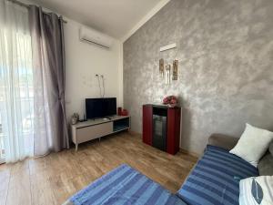 Una sala de estar con una cama y un televisor. en Il Frutteto Barbarossa, en Porto Azzurro