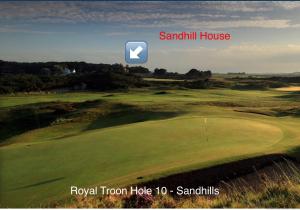 a picture taken from a distance of a grassy field with a blue sky at Sandhill House in Troon