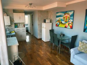 a kitchen and a living room with a table and a refrigerator at Exclusivo Departamento en Edificio Alessandria in Cochabamba