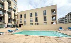 a swimming pool in front of a building at Ocean Escape Mimizan Beach in Mimizan-Plage