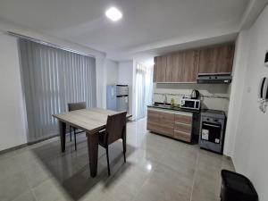Una cocina con una mesa de madera y un comedor. en Temporarios Eclipse, en El Carmen