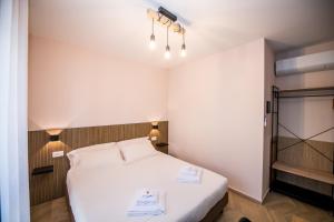 a small bedroom with a white bed and lights at Show MI Rooms Milano - Rho Fiera & San Siro - Free Parking in Milan