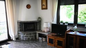 a living room with a fireplace and a television at Casa Sala in Castionetto di Chiuro