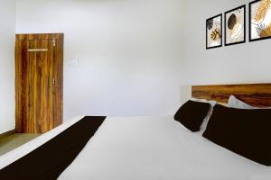 BilāspurにあるHotel O Pushkar And Restaurantの白いベッドと木製のドアが備わるベッドルーム1室が備わります。 +22枚の写真