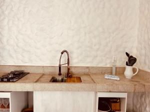 Una encimera de cocina con un fregadero y una estufa. en Greece house blue, en Paty do Alferes 13 fotos más