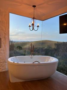Una bañera en una habitación con una ventana grande. en Greece house blue, en Paty do Alferes