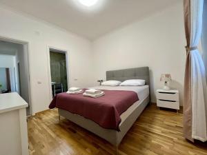 a bedroom with a large bed with a red blanket at Villa Bella Vita in Tivat