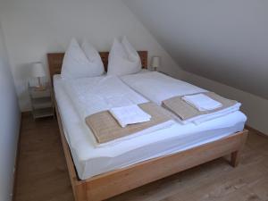 a bed with white sheets and towels on it at Száka Kőház in Balatonfüred +4 photos