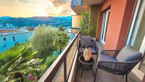 a balcony with chairs and a view of the city at Oasis Apartment with Free parking in Lugano
