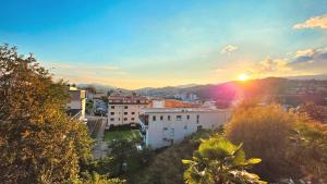 a view of a city with the sun setting at Oasis Apartment with Free parking in Lugano
