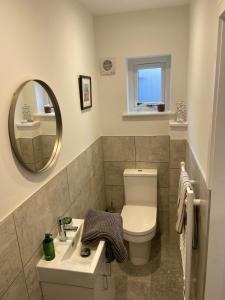 ein Badezimmer mit Toilette, Waschbecken und Spiegel in der Unterkunft Luxury Apartment St Andrews in St Andrews