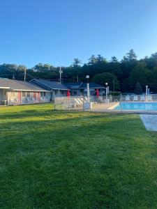 a park with a swimming pool and a building at Barberry Court Motel &Cabins in Lake George