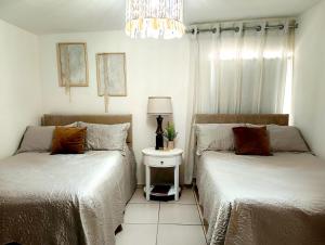 a bedroom with two beds and a table with a lamp at Escala Norte in Hermosillo