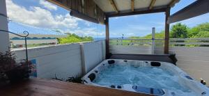 a hot tub on the back of a house at Gîtes Capra Pomme Surette piscine et spa in Bouillante