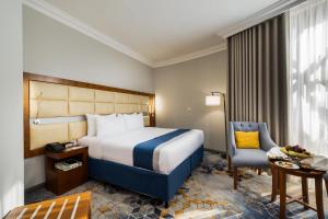 a hotel room with a bed and a desk and a chair at Emaar Elite Al Madina Hotel in Al Madinah +89 photos