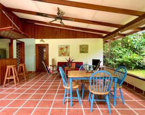a patio with a wooden table and chairs at Los Delfines Lodge in Puerto Viejo